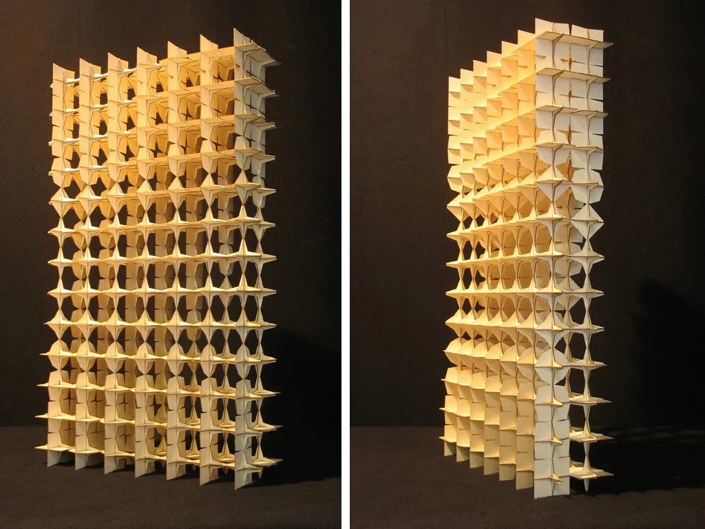 Two photographs of a tall lattice model of cast elements, lit warm against a black ground