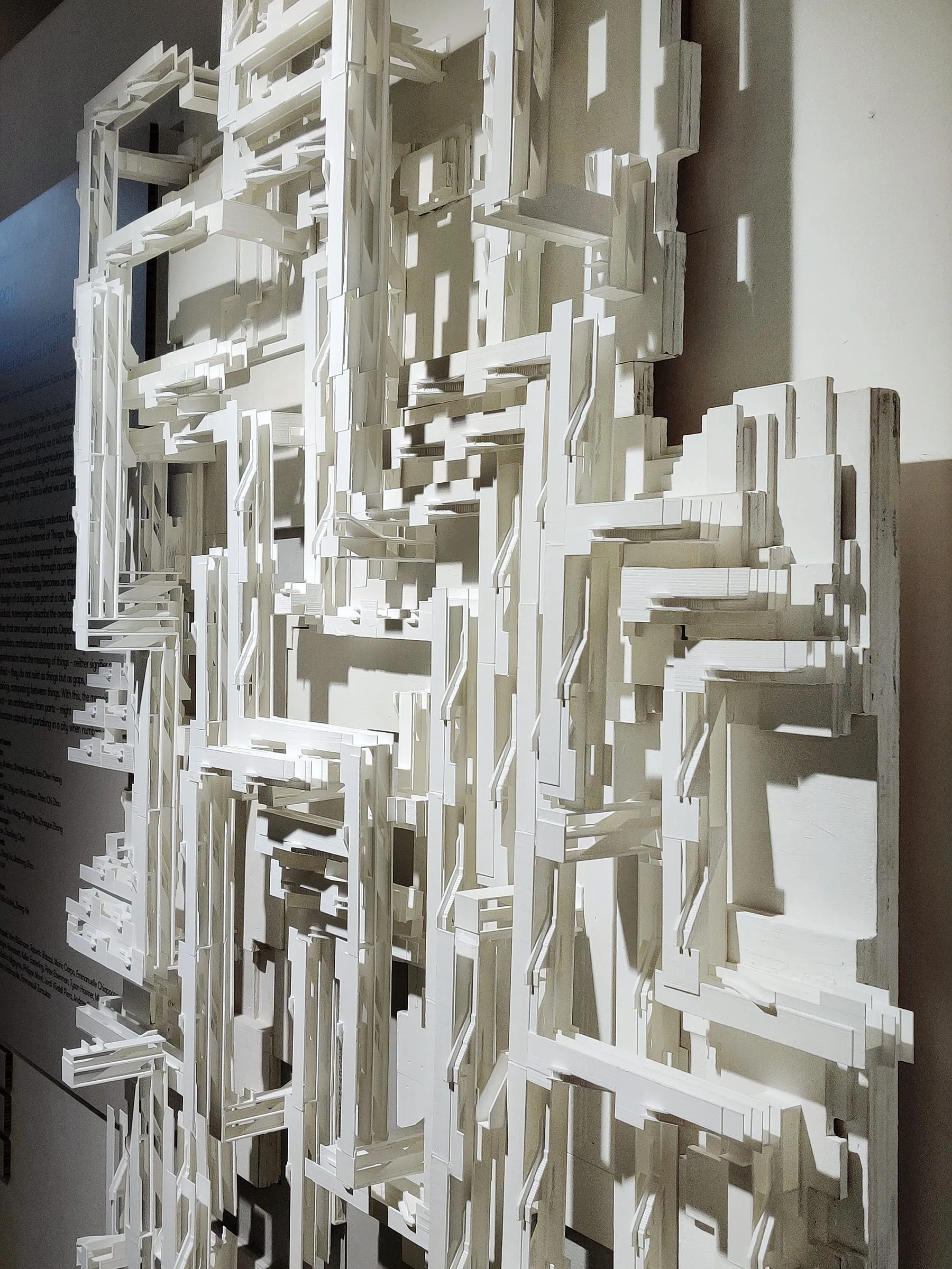 Tall white model of stacked, staggered slabs and terraces read as one continuous landscape