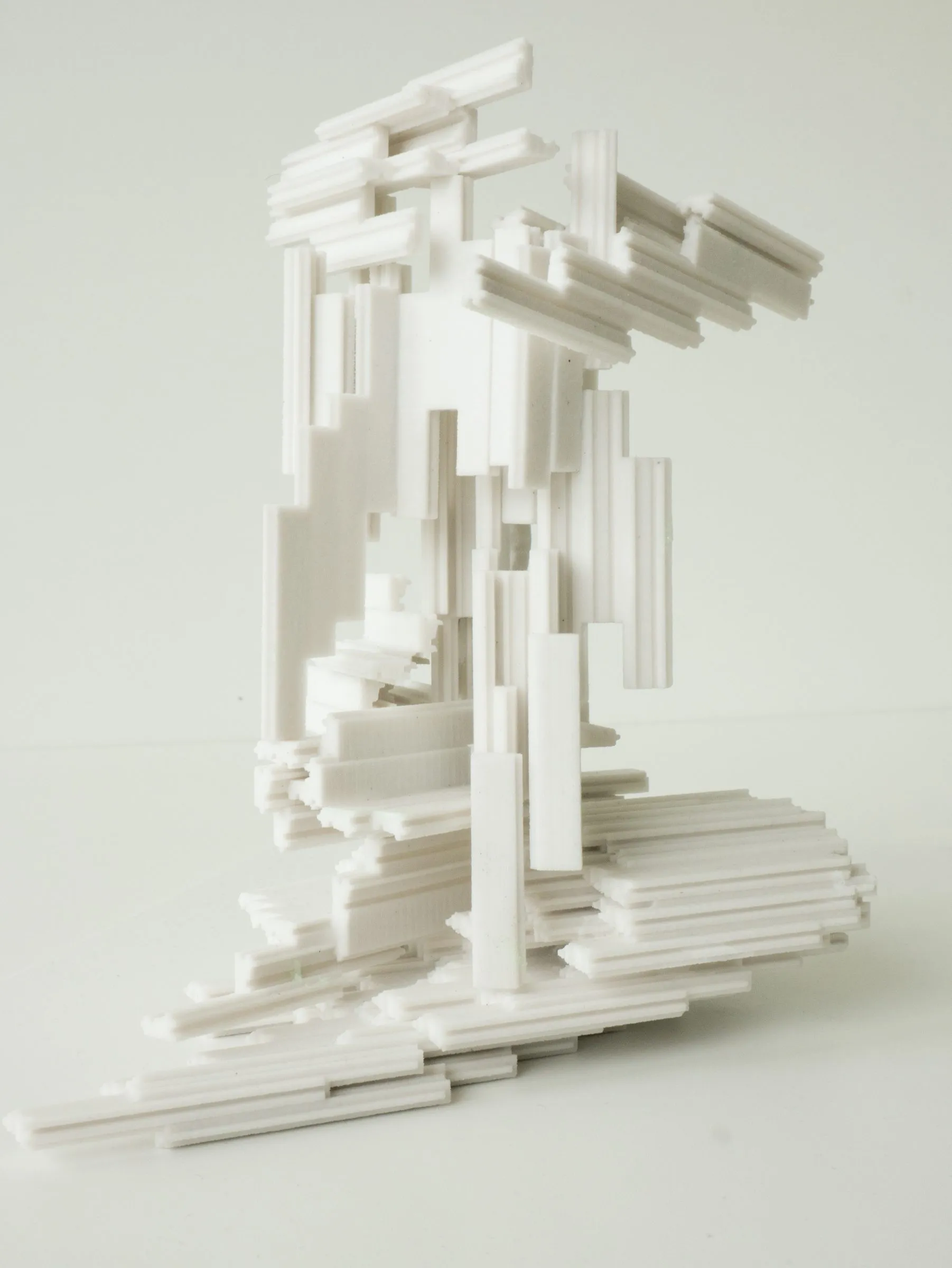 The white model seen from the side: a tower of frames with a stepped, striated surface