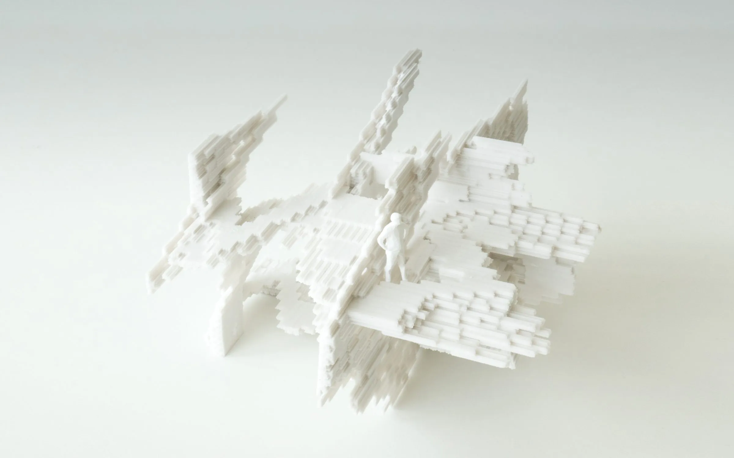 A white 3D-printed model of stacked stepped frames on a white ground
