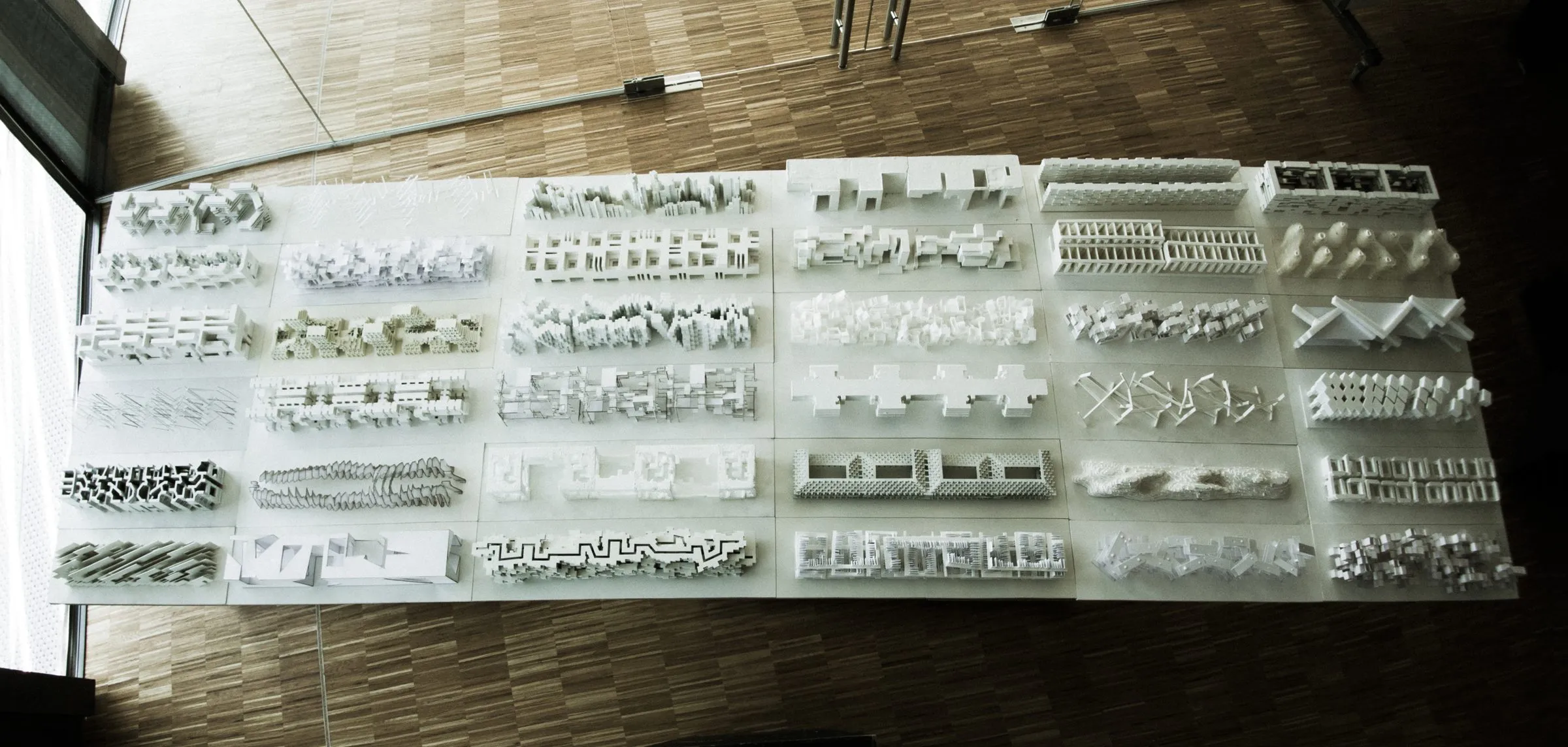 The table of white student models seen from above: rows of slabs of the same size with different internal configurations