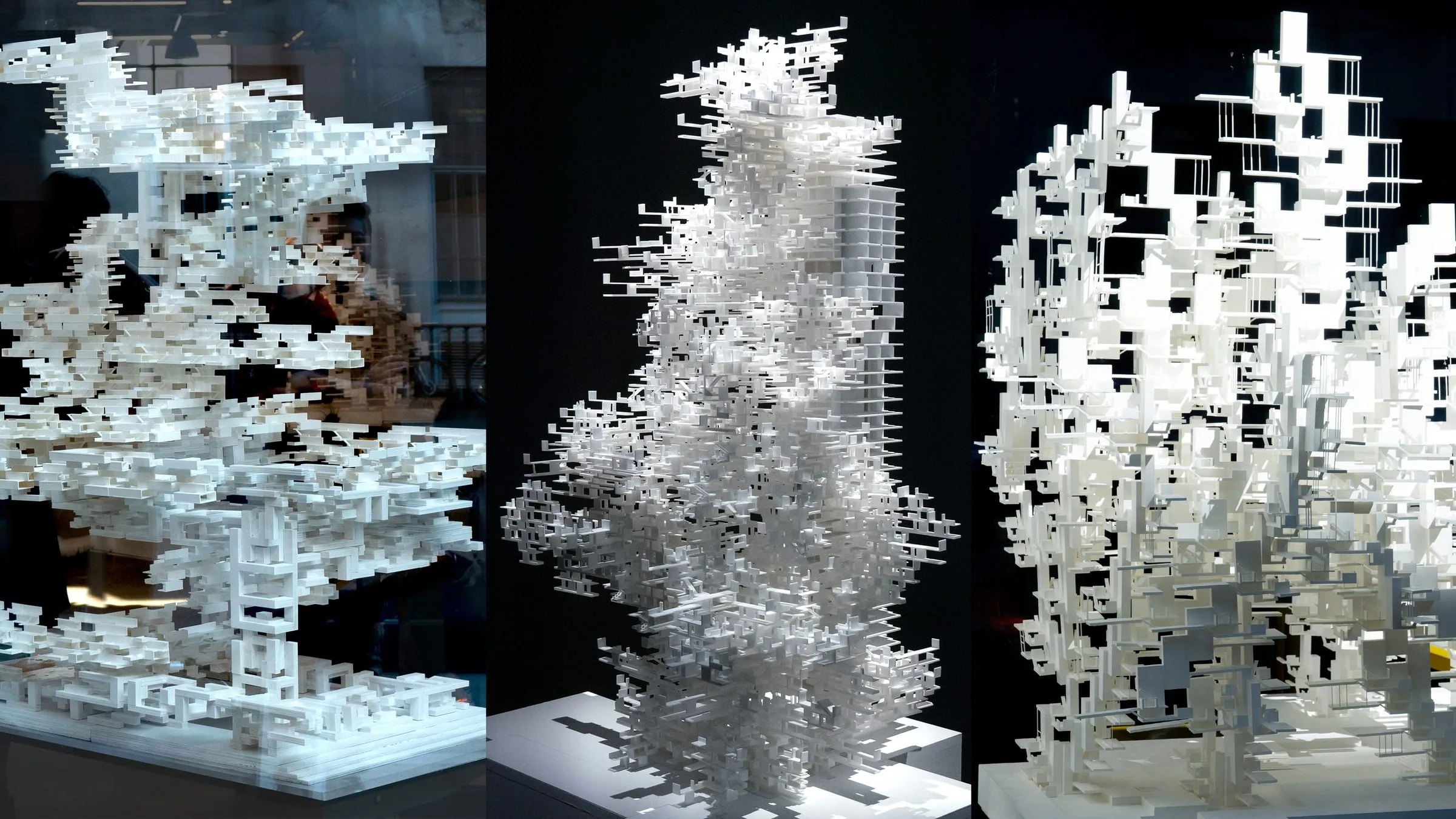 Three photographs of white models of nested figures on black