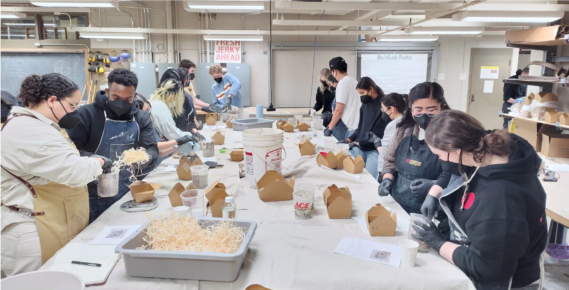 Students around a table making material samples in the workshop