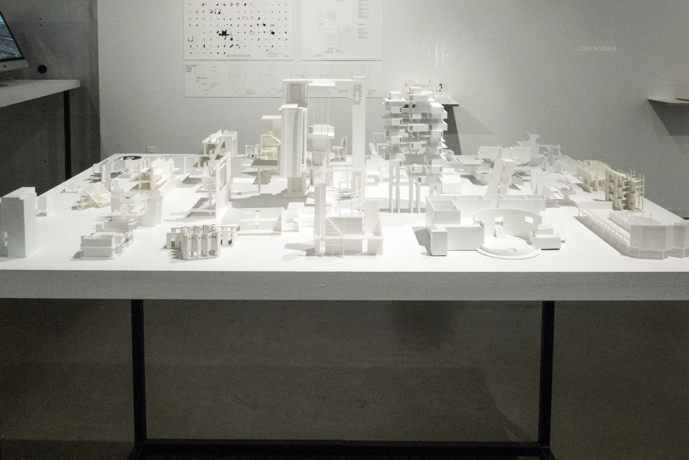 A table of white models under gallery light