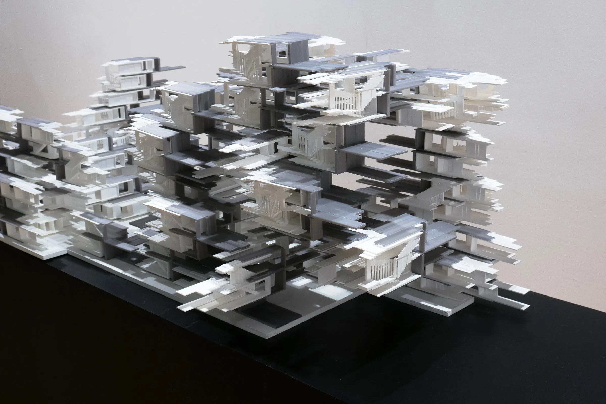 Close view of the model: stepped terraces of white and grey slabs with small stairs and openings