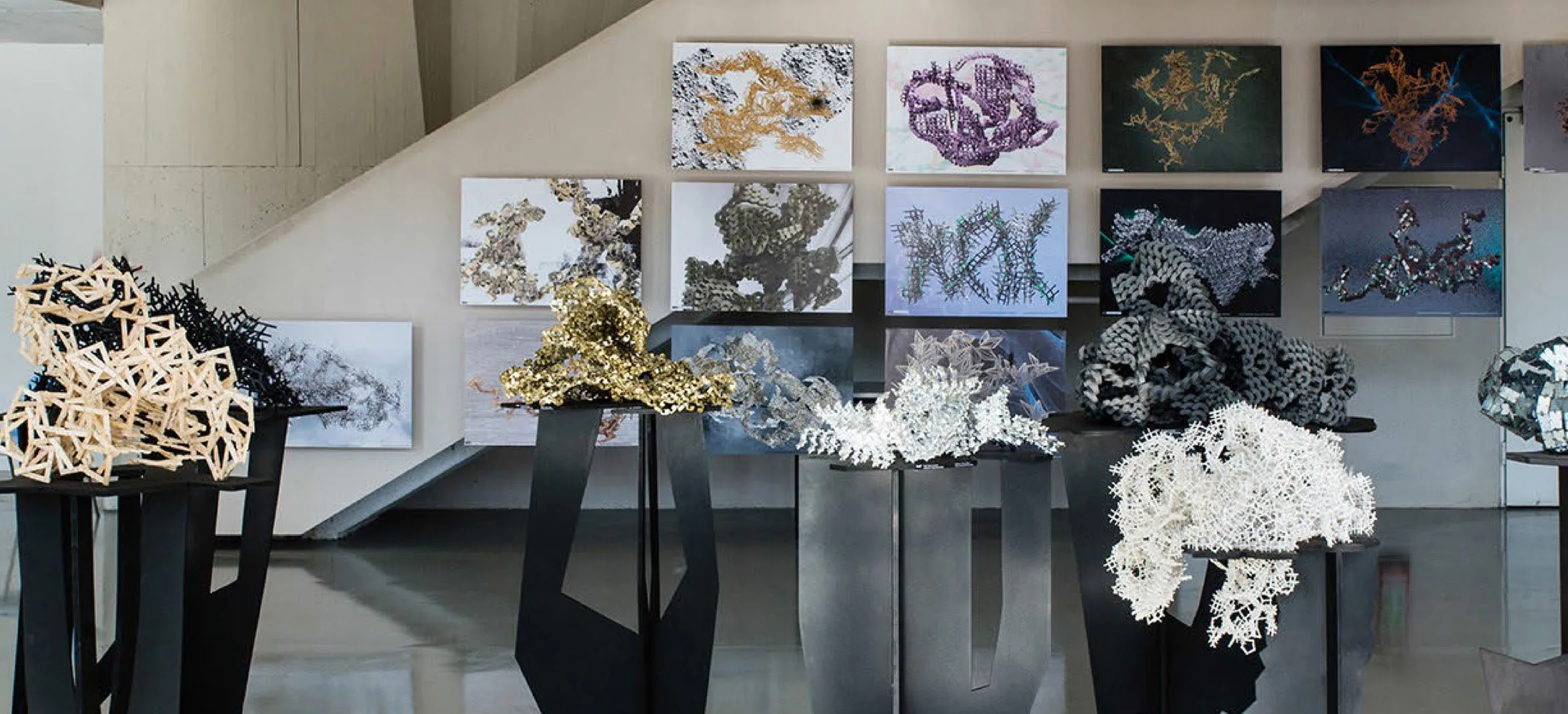 Exhibition view with aggregate models on plinths and drawings on the wall