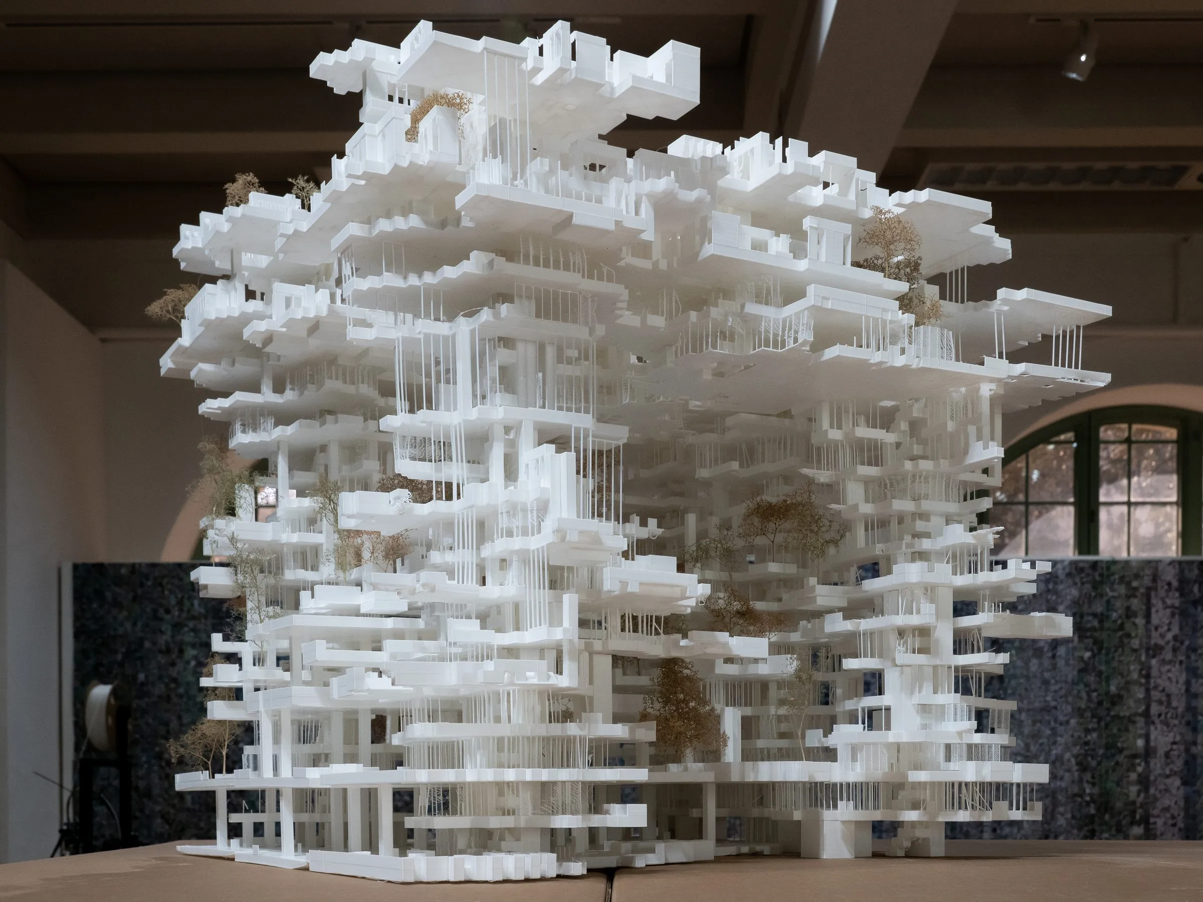 The model seen from an angle, its top slabs projecting over the lower levels