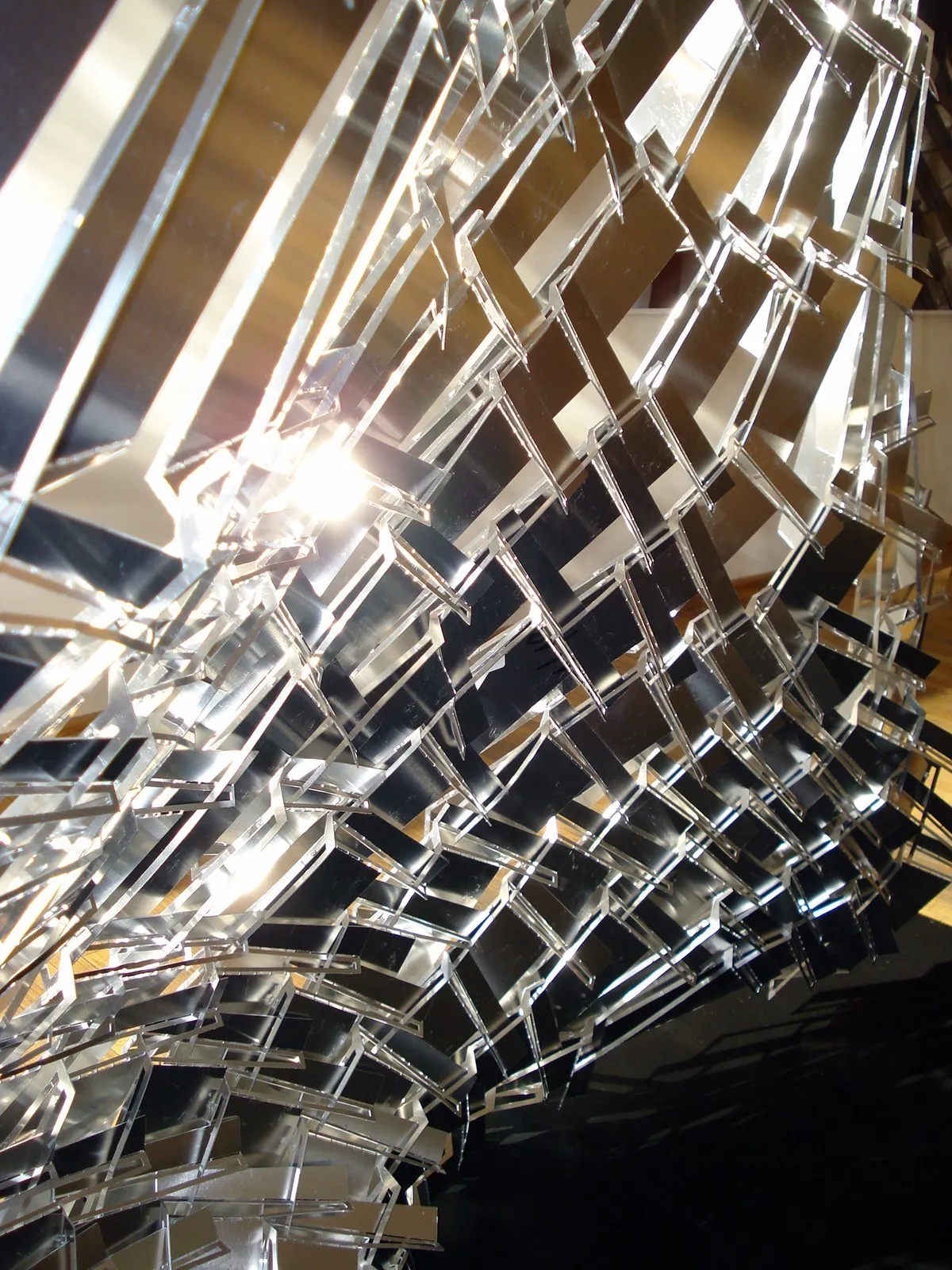 An installation of mirrored metal strips seen from below